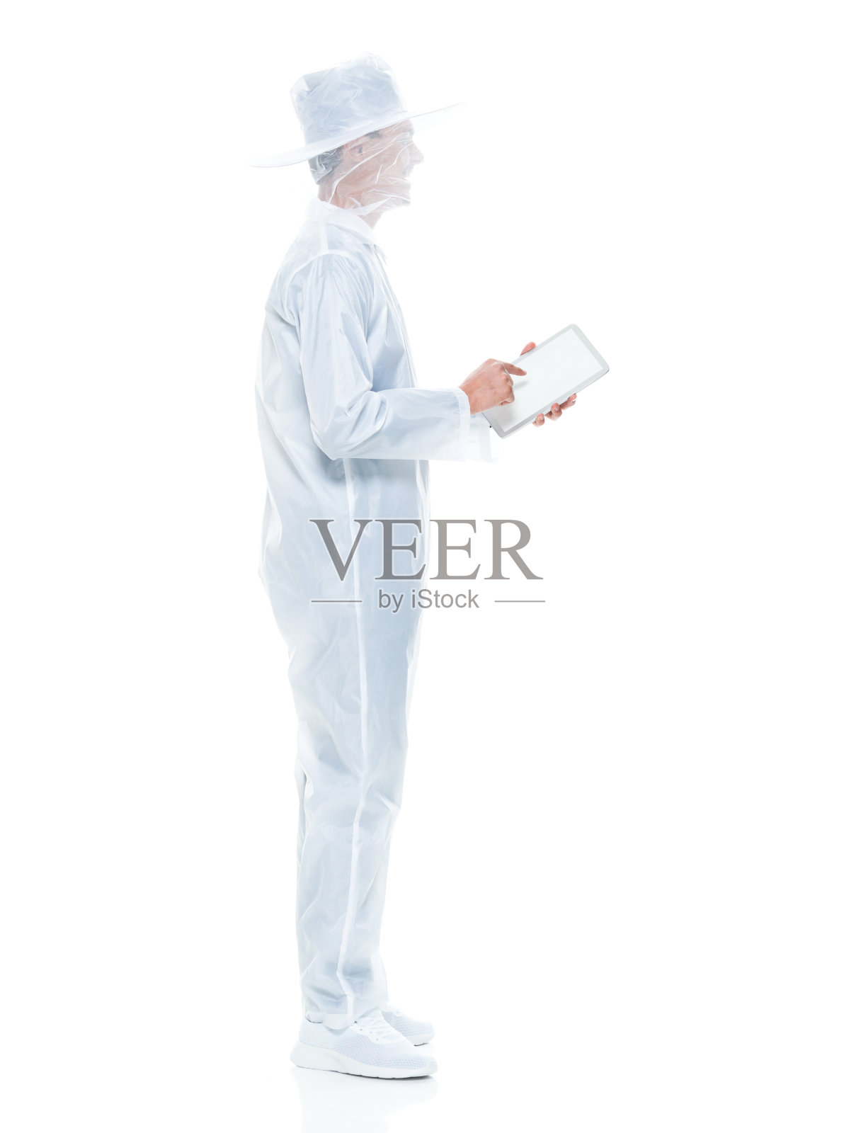 非裔美国人年轻男性穿着工作服站在白色背景前，用着数字平板电脑照片摄影图片