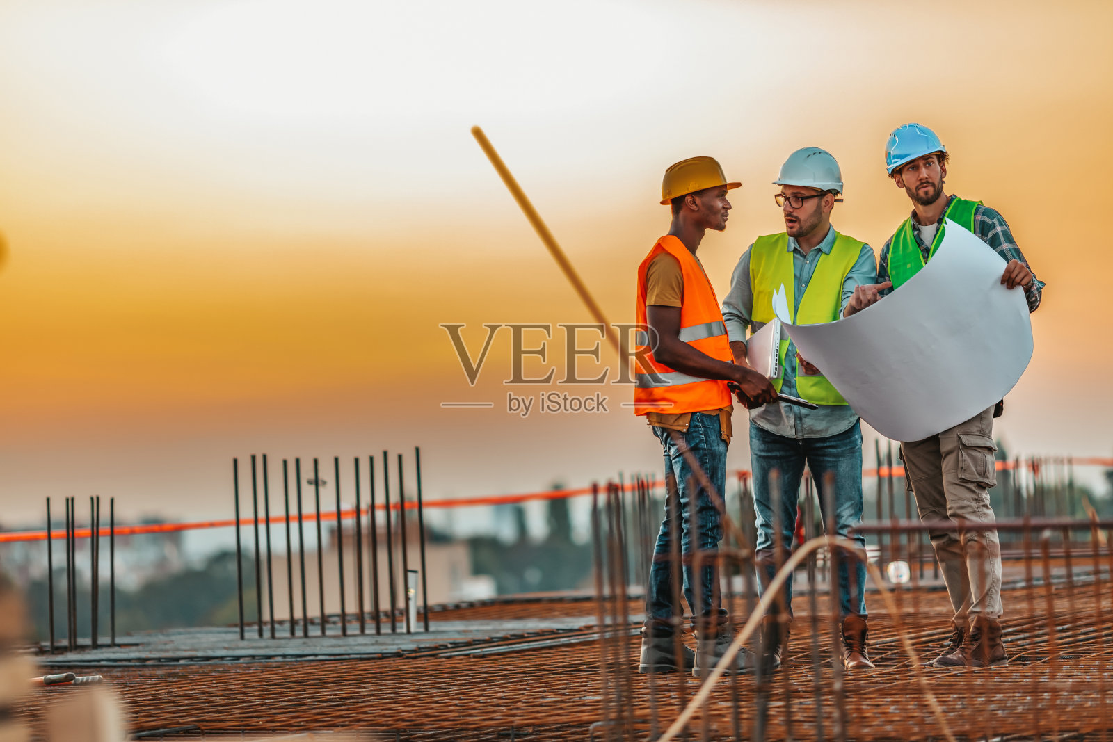 男建筑承包商在建筑工地向一群工人发号施令照片摄影图片