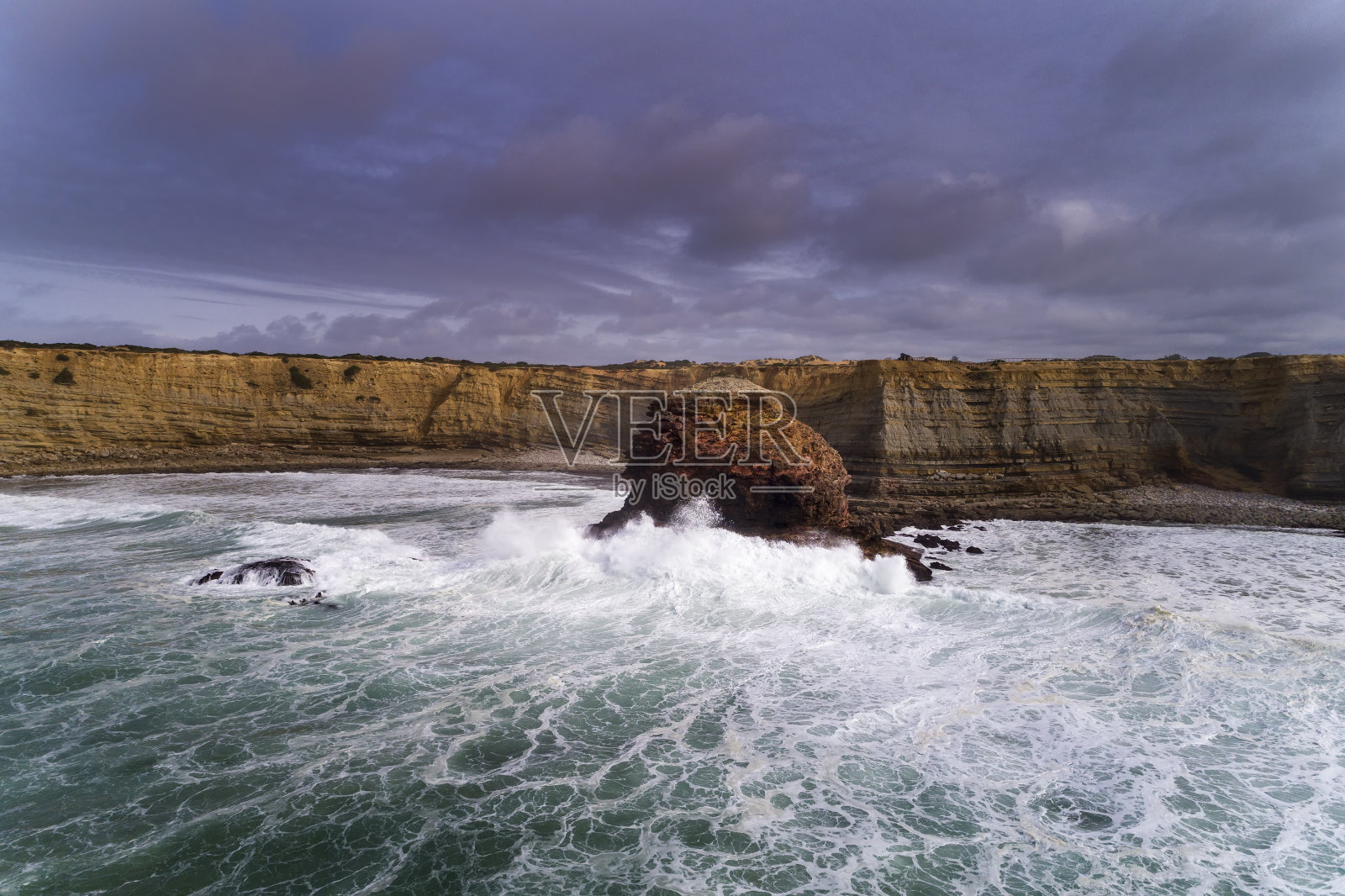 在阿尔加维的波尔多海滩附近，一架无人机拍下了海浪撞击岩石的美丽海岸线照片摄影图片