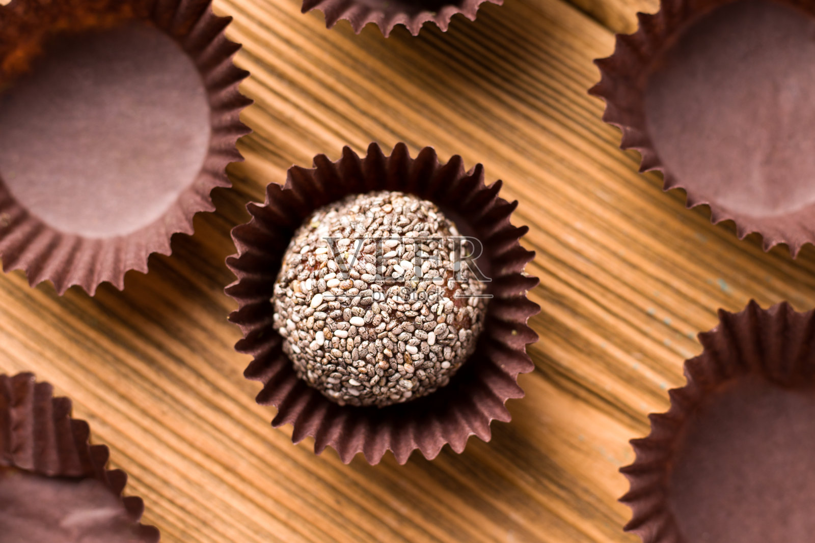 木桌上放着带奇亚籽的干果能量球。照片摄影图片