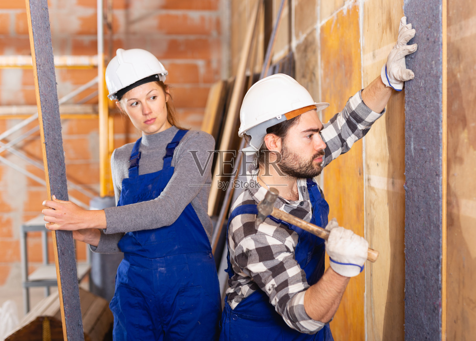两位专业建筑工人用绝缘材料覆盖墙壁照片摄影图片