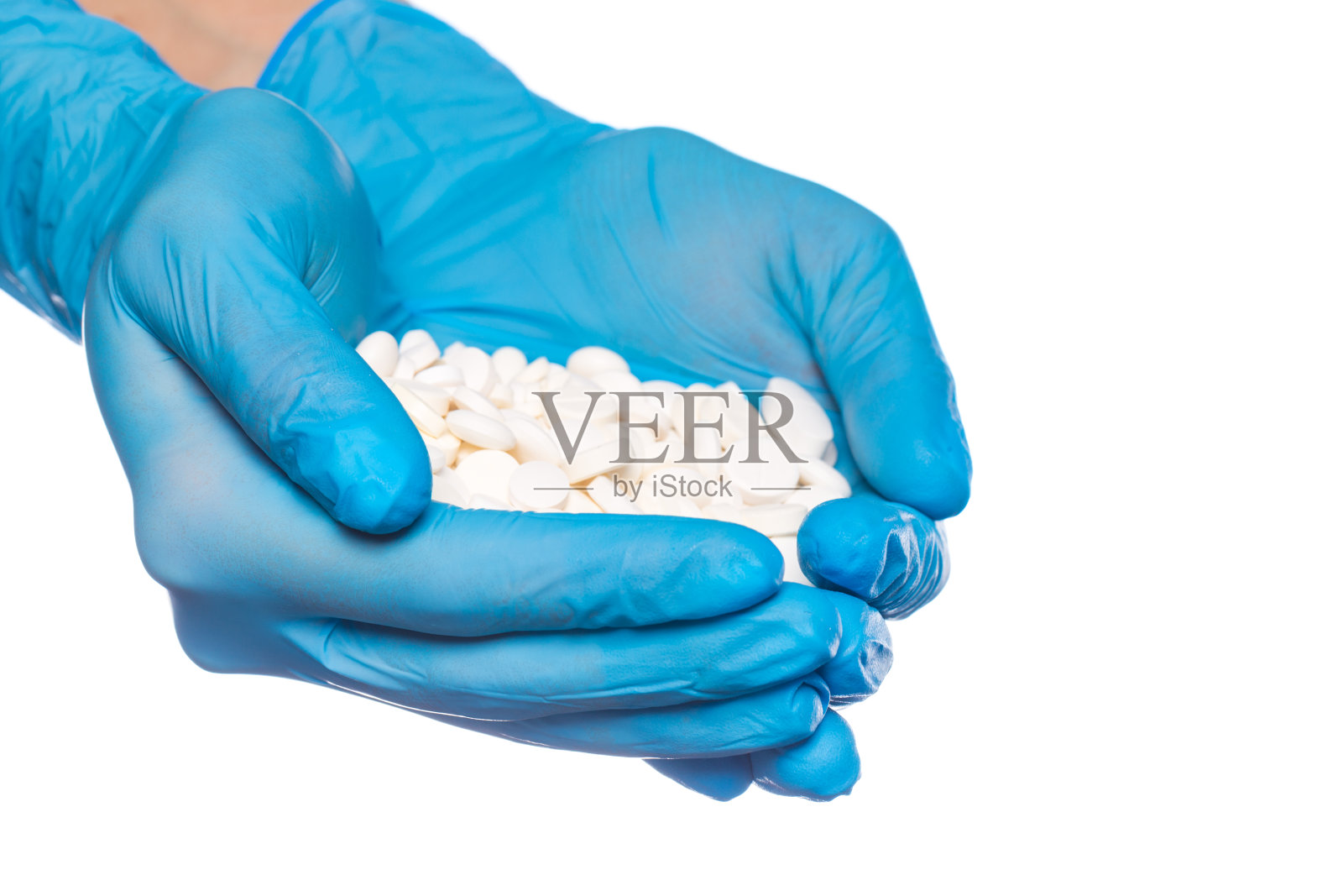 戴蓝色医用手套的外科医生手持药丸泡罩，白色背景照片摄影图片