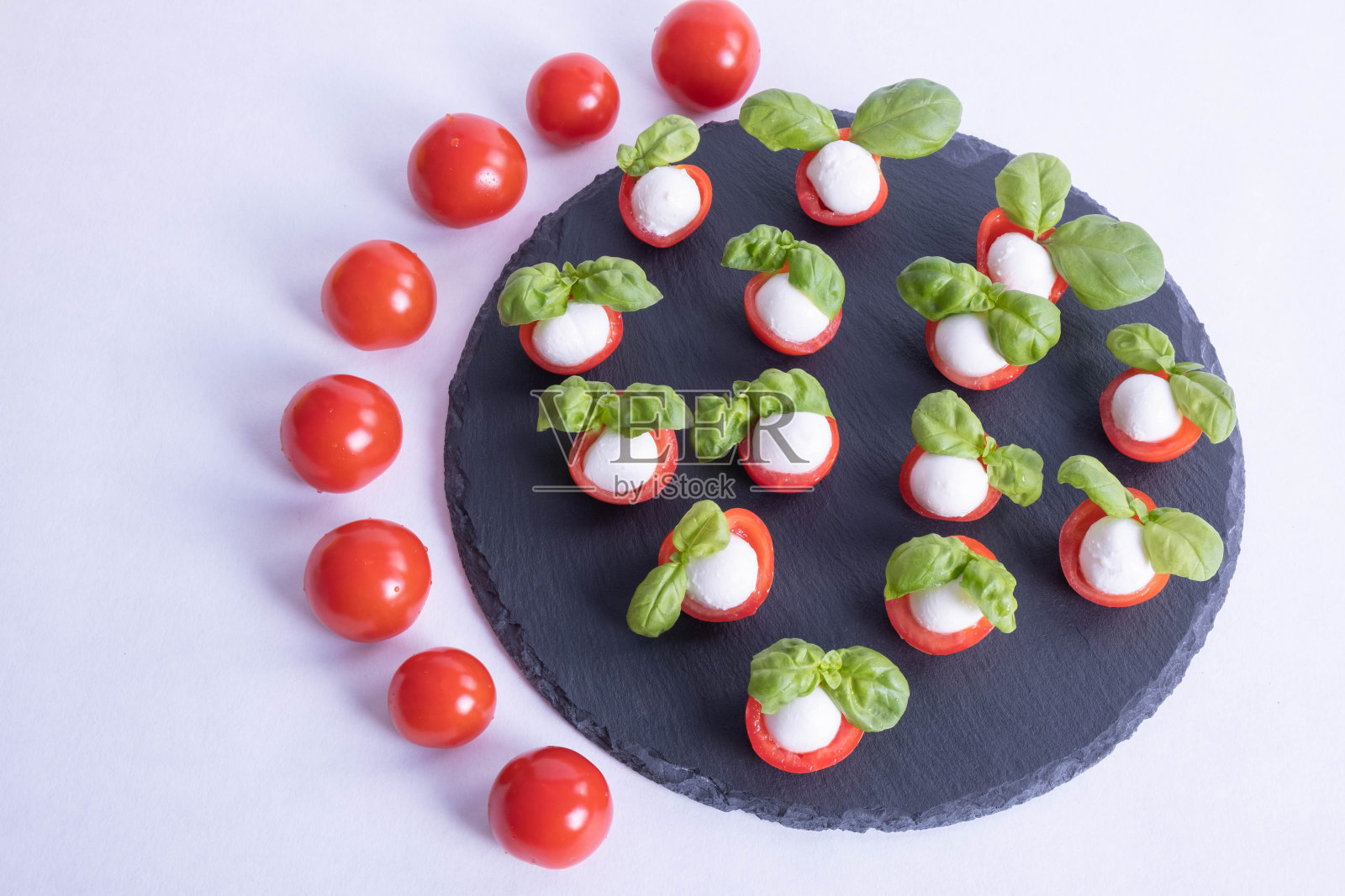 罗勒，西红柿和马苏里拉奶酪在石头黑色瓷砖上照片摄影图片