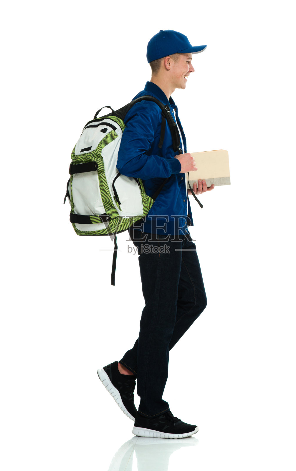 背着背包拿着教科书的男高中生站在白色背景前照片摄影图片