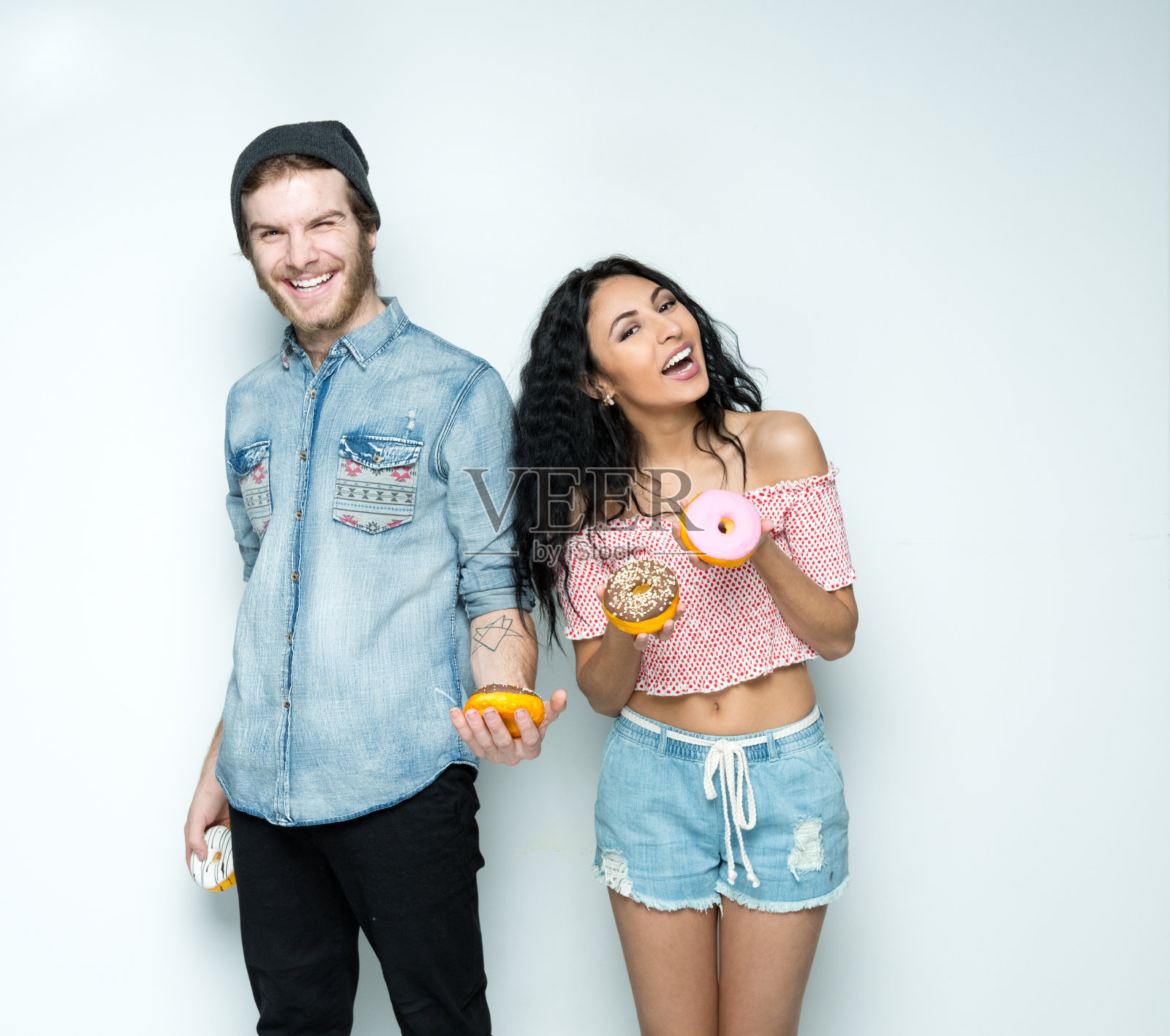 穿着短裤拿着甜甜圈的潮男照片摄影图片