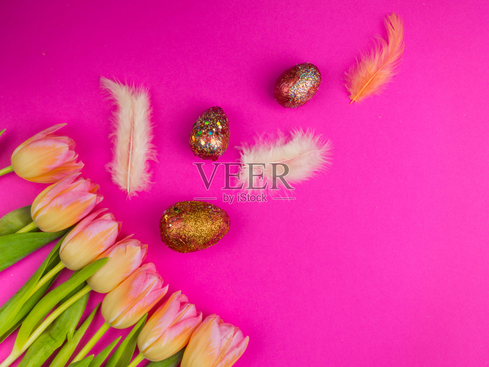 粉红色背景上有郁金香的复活节彩蛋照片摄影图片