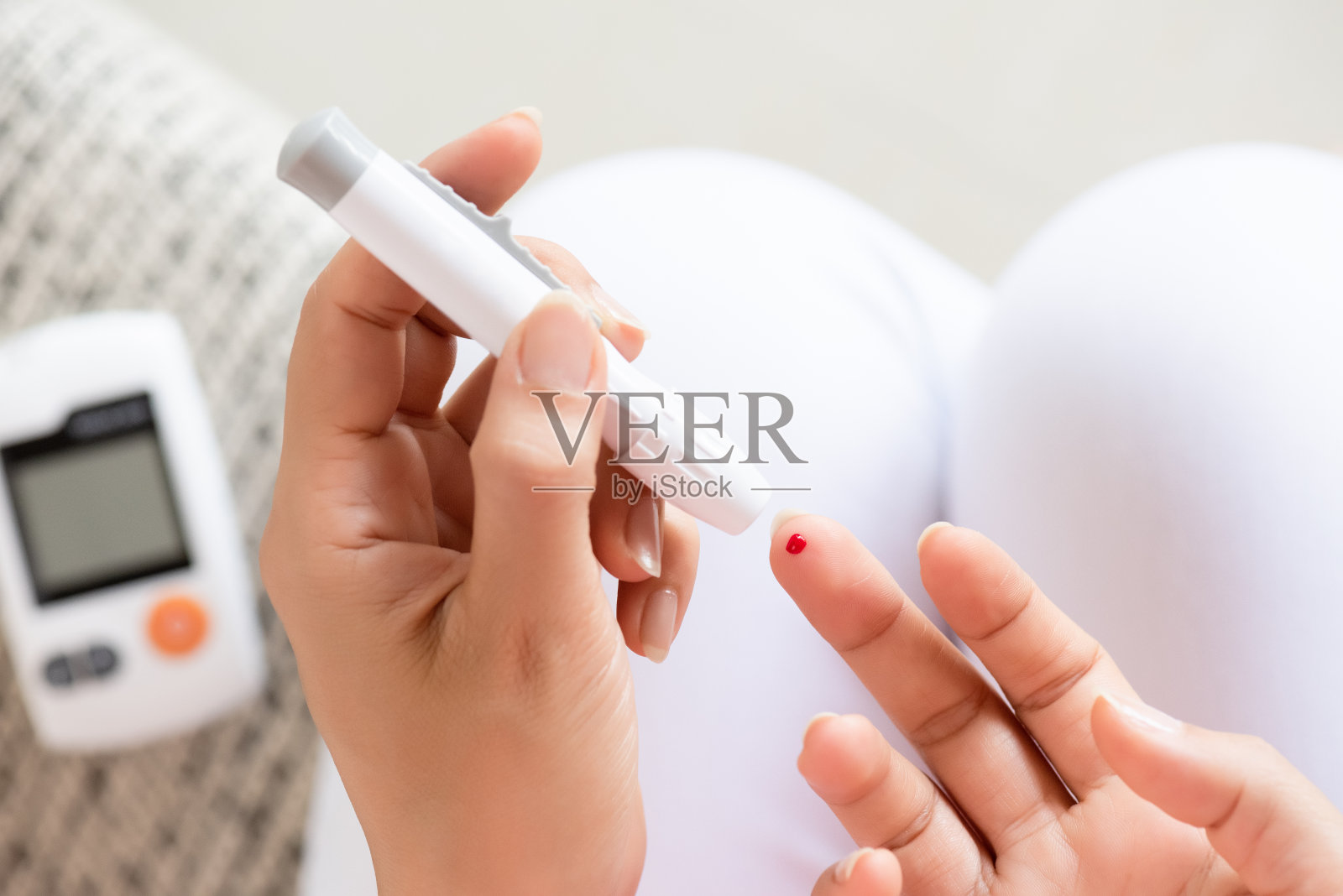 女人用采血器检测血糖特写，用于糖尿病检测照片摄影图片