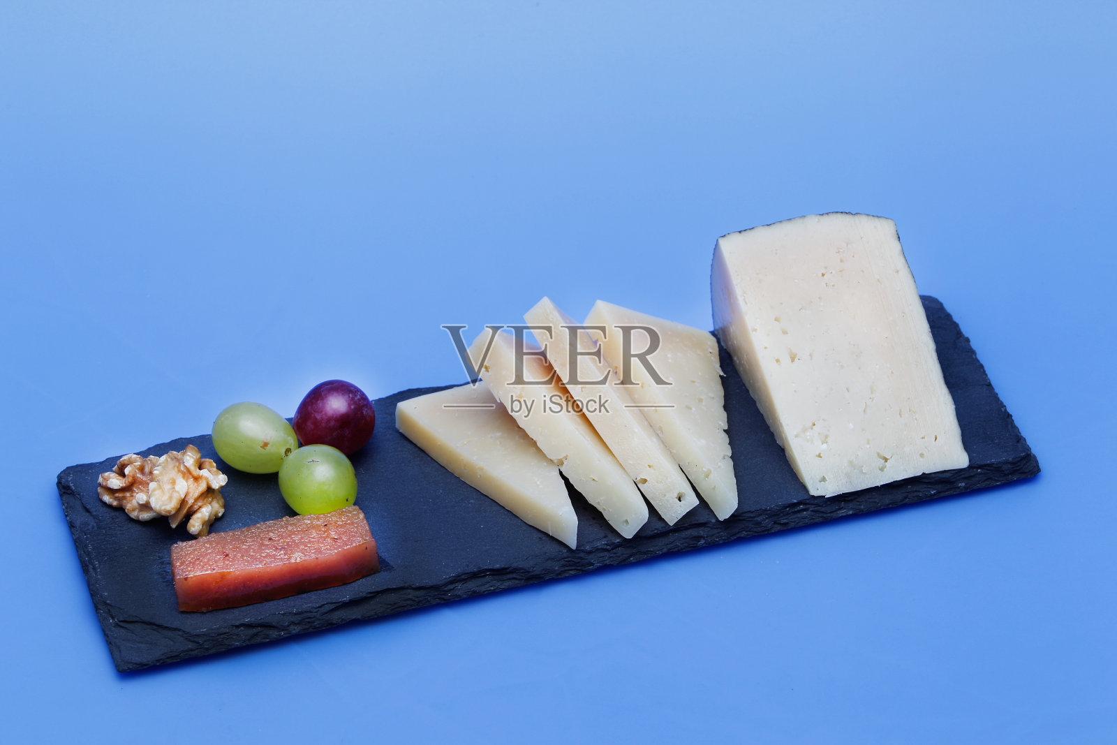 楔形的腌制曼彻格奶酪。照片摄影图片