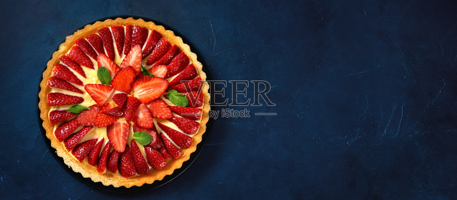 俯视图新鲜草莓挞在时尚的深蓝色背景照片摄影图片