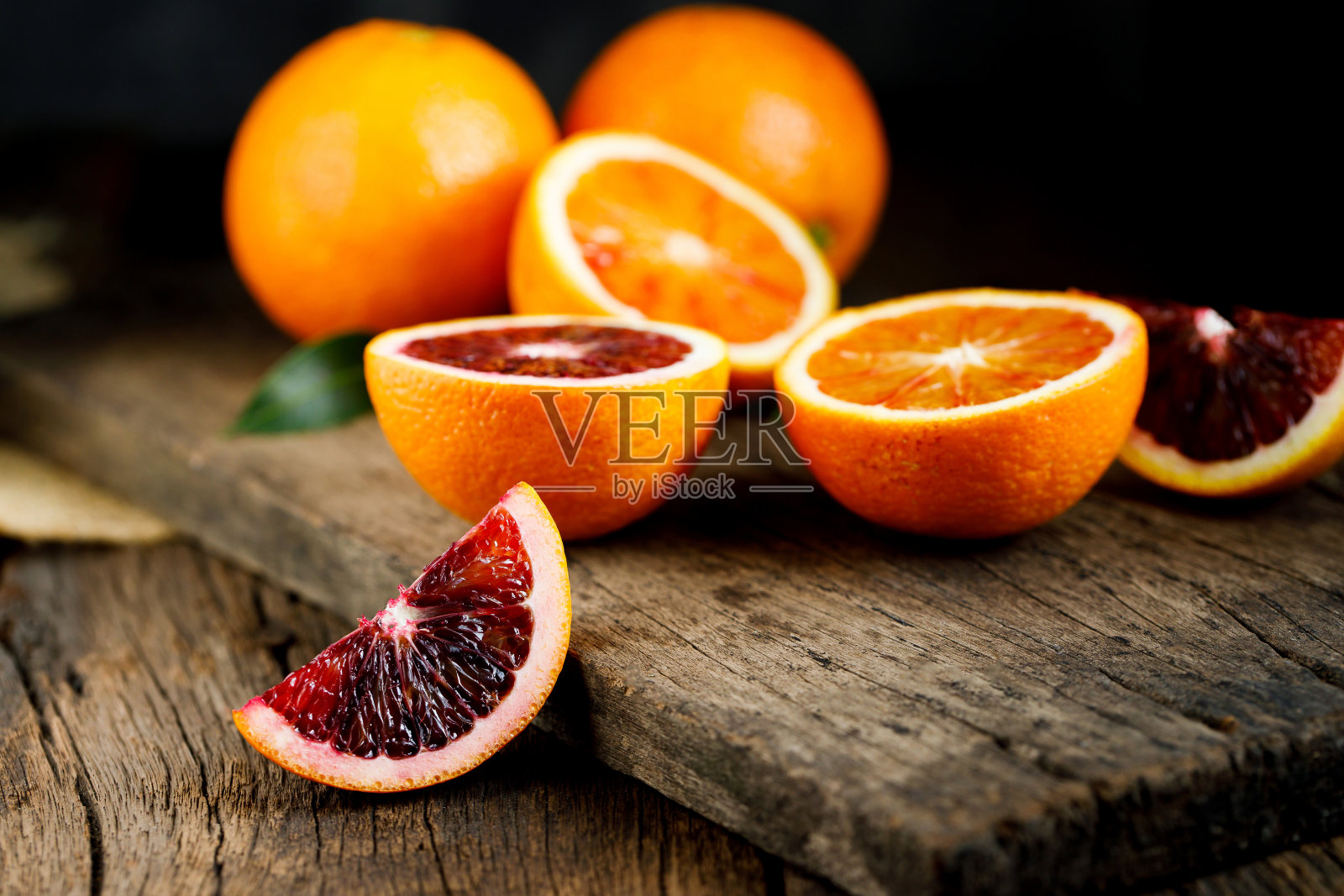 切成薄片的西西里血橙水果在古老的深色木制背景上。前视图。照片摄影图片
