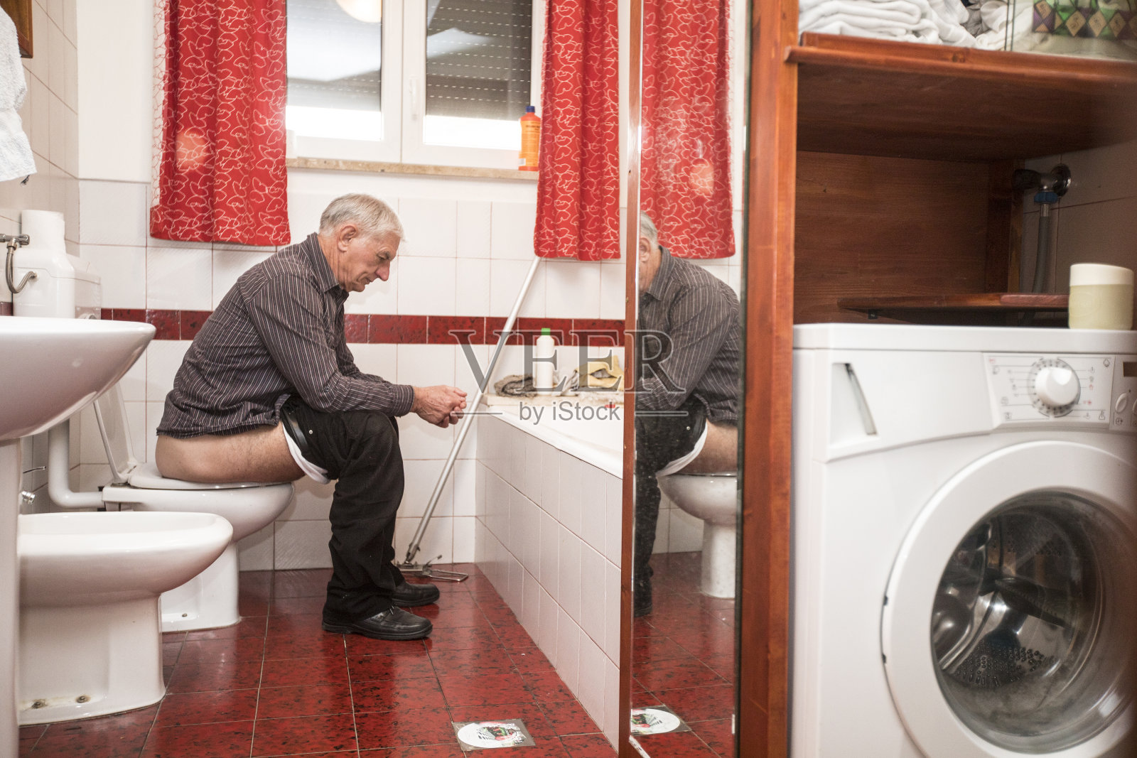 坐在马桶上的老人烫伤了照片摄影图片