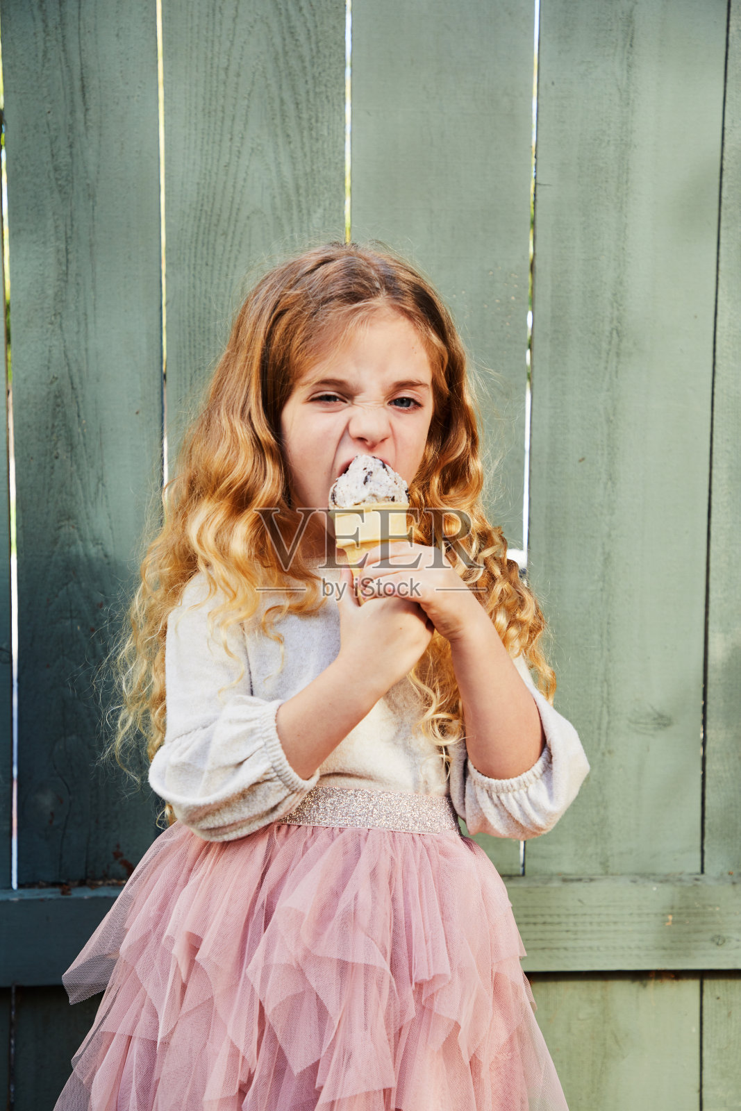 可爱的小女孩在院子里吃冰淇淋照片摄影图片