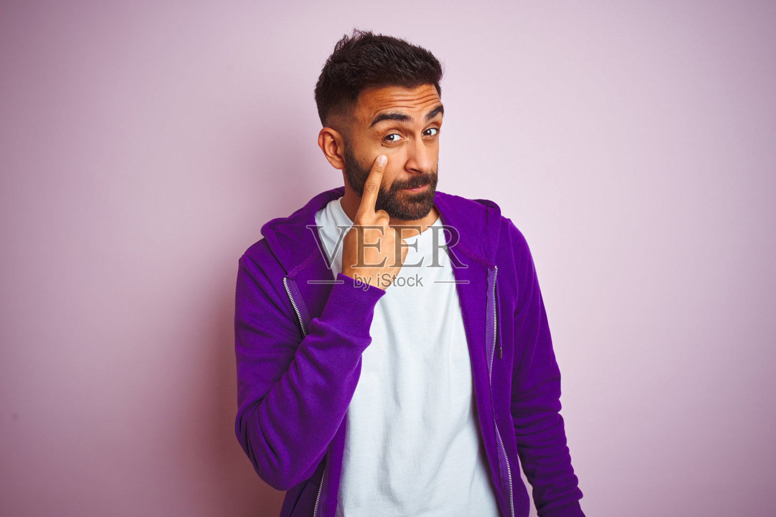 年轻印度男人怀疑指眼照片摄影图片