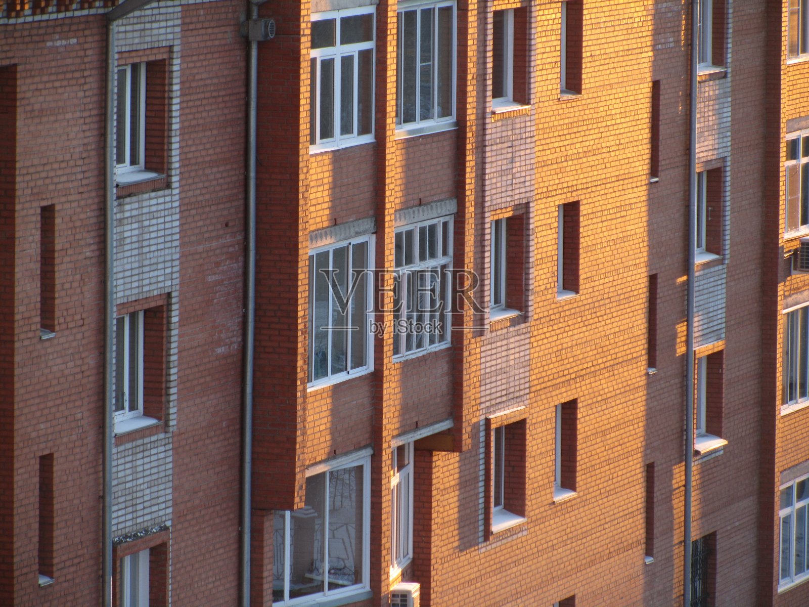 带有窗户和阳台的砖房墙壁的透视图。照片摄影图片