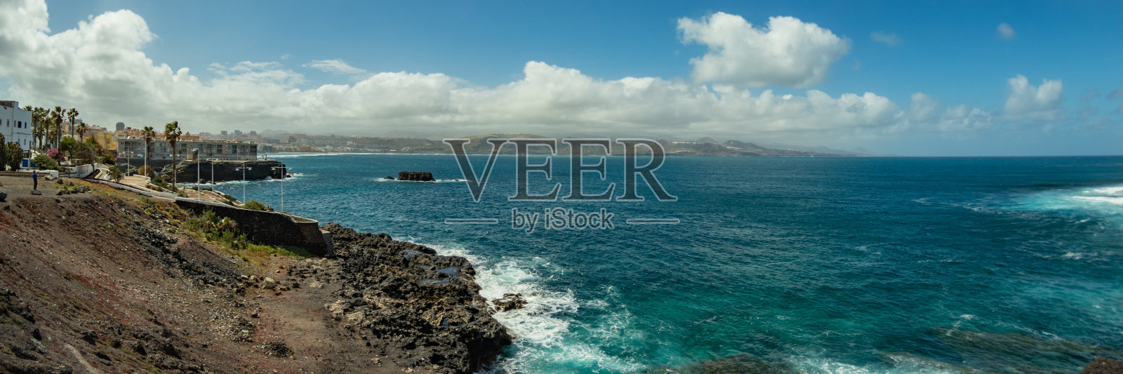 拉伊斯莱塔的超大全景图，一个温暖的阳光明媚的日子，明亮的蓝天和白云。拉斯帕尔马斯，拉斯坎特拉斯海滩，大加那利岛照片摄影图片