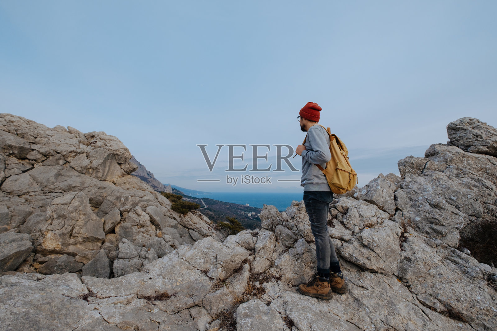 男人背包徒步旅行和红帽子在山区照片摄影图片