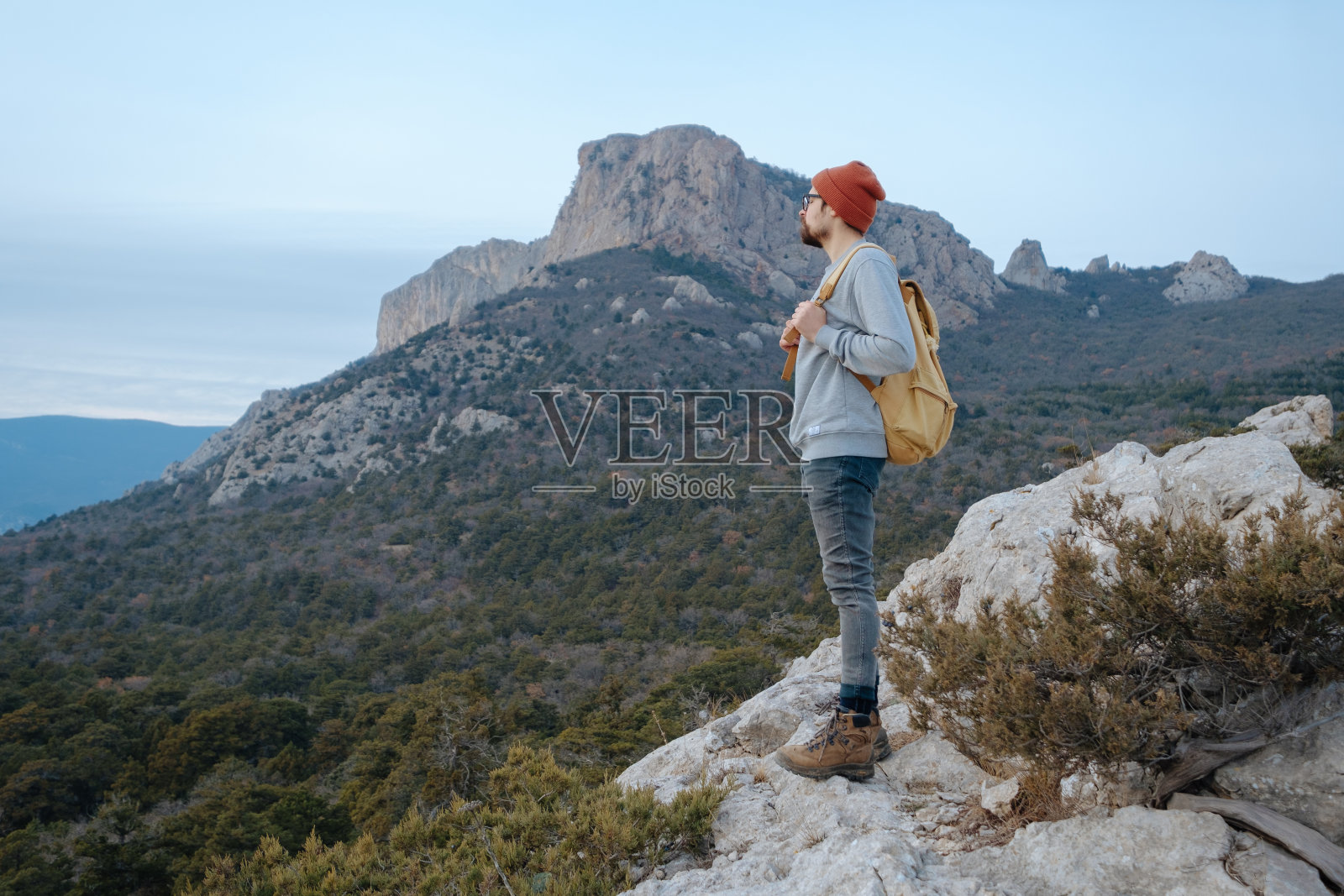 男人背包徒步旅行和红帽子在山区照片摄影图片