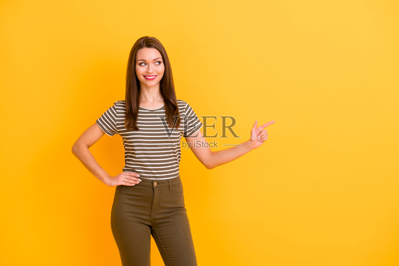 正面欢快的肖像推广点食指复制空间推荐广告，指示推广穿现代青年服装孤立过亮颜色背景照片摄影图片