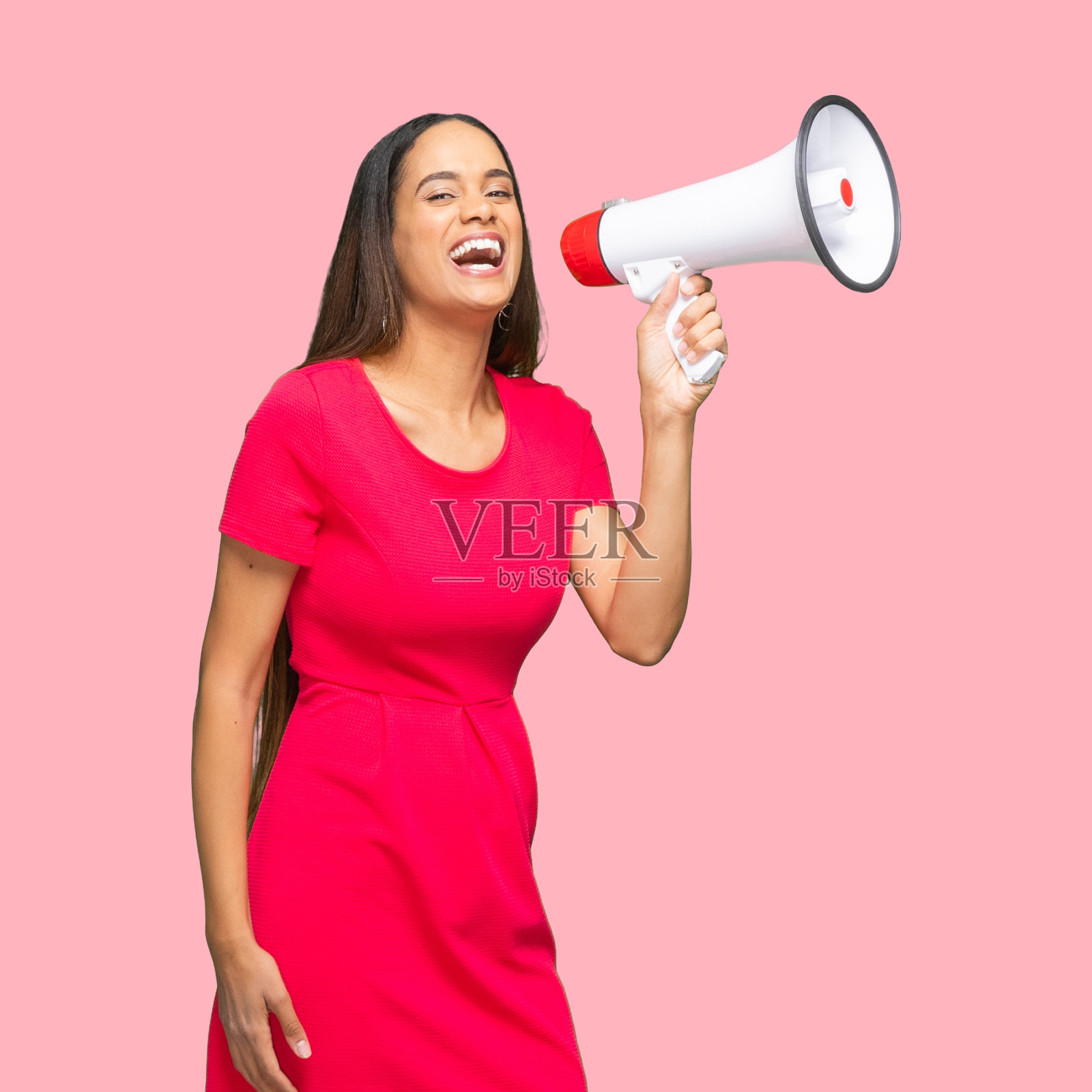 站在彩色背景前，身穿连衣裙的非洲裔女性拿着扩音器照片摄影图片
