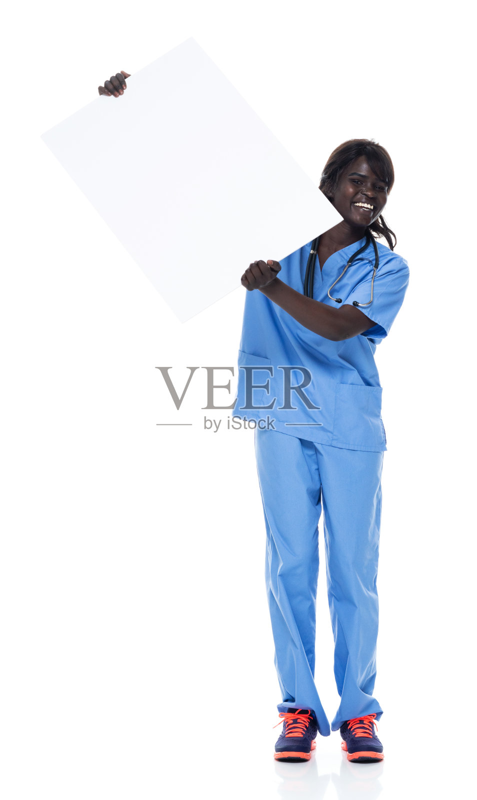 非洲裔年轻女性穿着运动鞋举着牌子站在白色背景前照片摄影图片