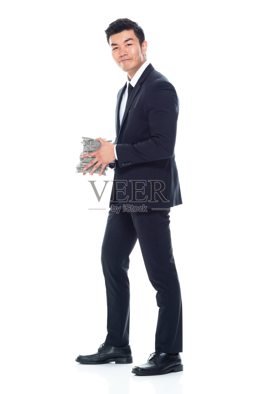 站在白色背景前，系着领带，拿着货币的东亚男商人照片摄影图片