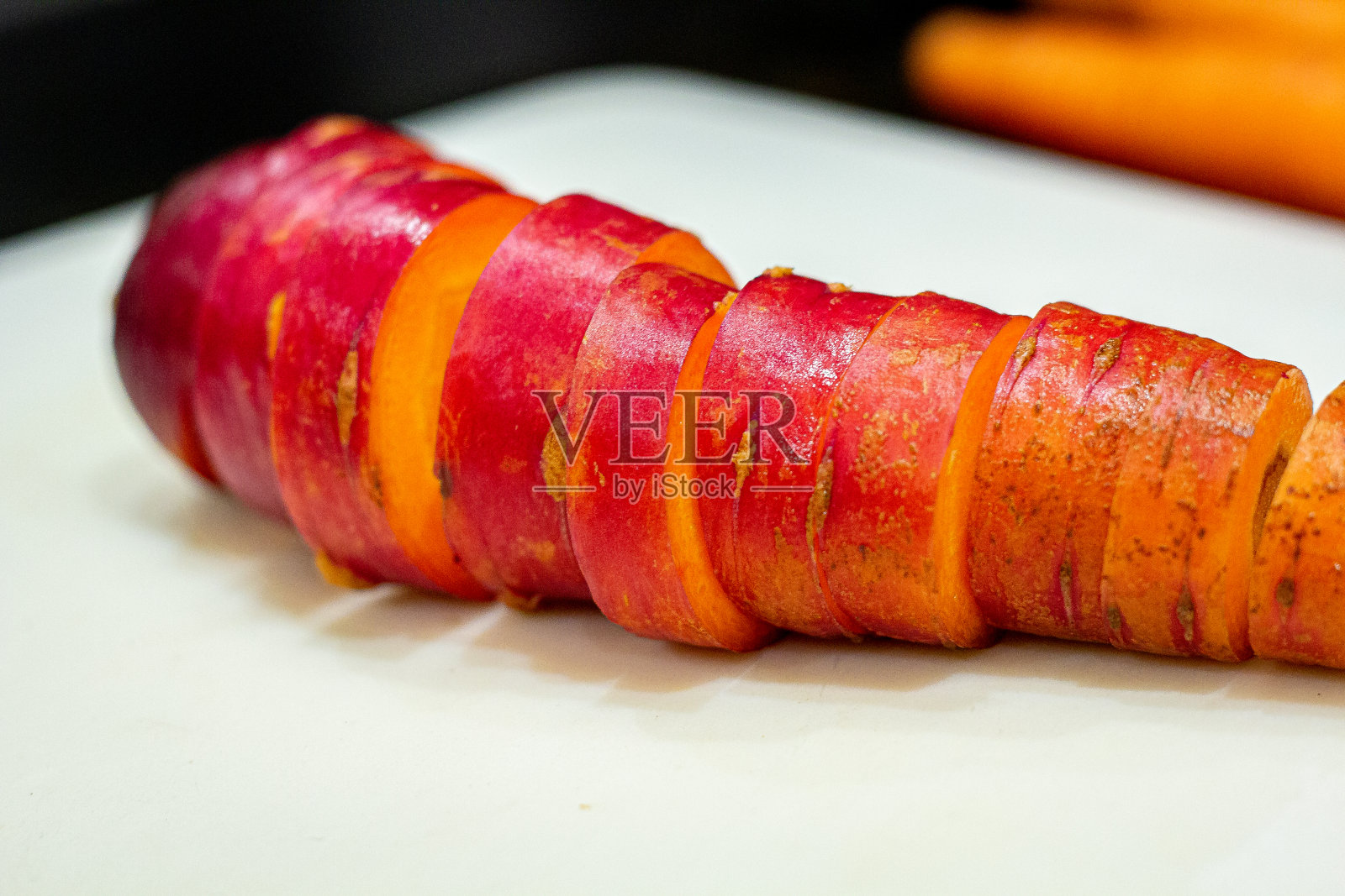 一堆美味的生的新鲜切碎的有机本地采购原子红色明亮的颜色大胡萝卜在白色塑料切板的背景照片摄影图片