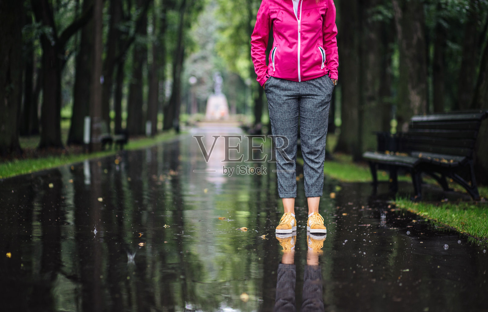 手插在口袋里站在雨里的女人照片摄影图片