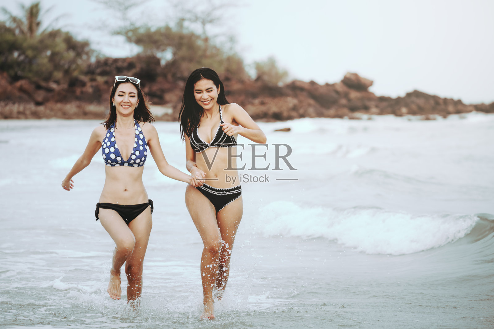 女人和朋友在海滩上跑步照片摄影图片