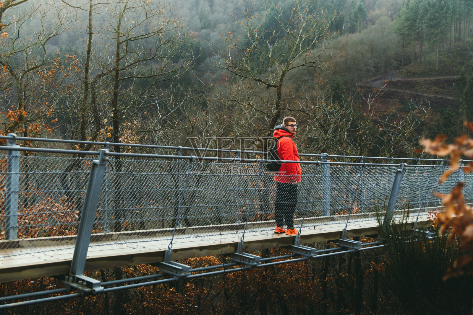 一个背包客在吊桥上散步，欣赏德国自然美景照片摄影图片