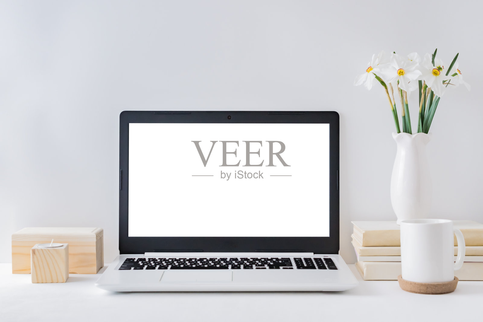 办公室场景：带有笔记本电脑模型、书籍和白色水仙花照片摄影图片