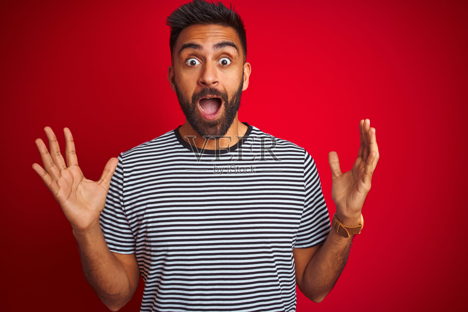 举起双臂为成功疯狂欢呼的年轻印度男人照片摄影图片