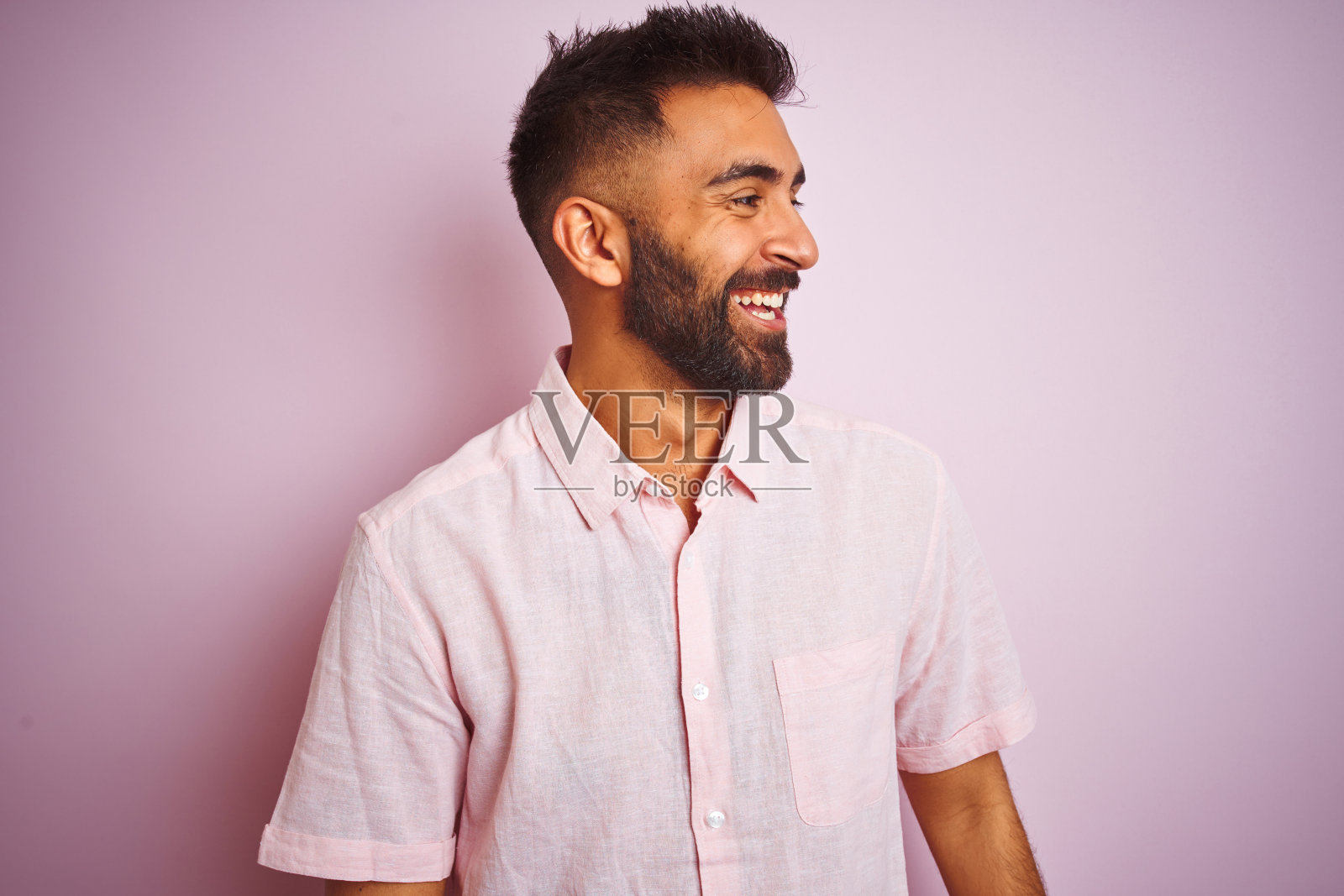 印度青年面带微笑，看向一侧照片摄影图片