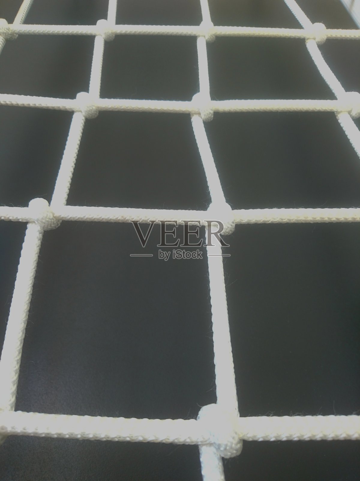 黑色背景上用粗绳织成的白色网。照片摄影图片