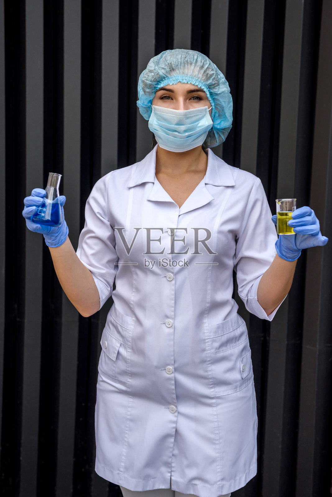 正在用试管和防护服做实验的女化学家照片摄影图片