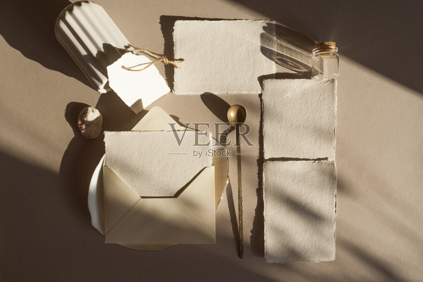 空白的白色婚礼问候邀请卡模型与工艺信封，标签，干燥的热带棕榈叶，花瓶盘子，在木制纹理的桌子背景。优雅的现代模板。平放俯视图照片摄影图片