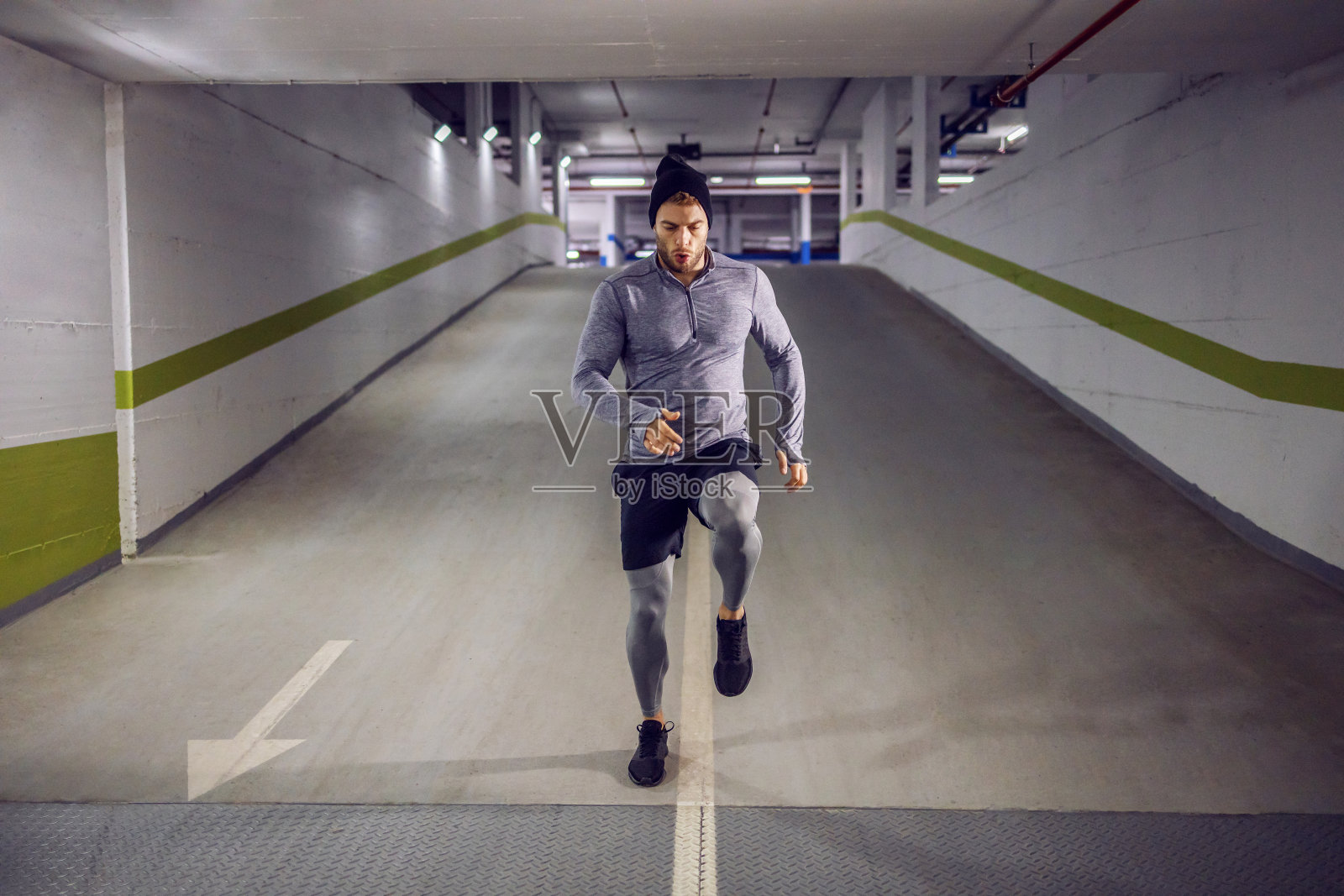 年轻健壮的运动员在地下车库跑步照片摄影图片