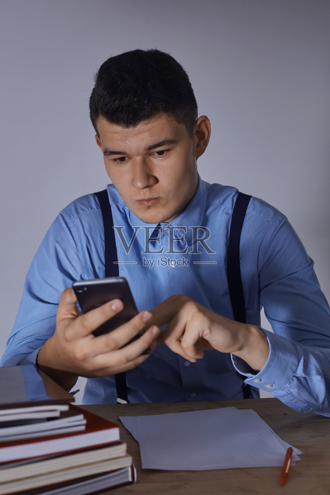 商务男士在办公室用智能手机阅读信息照片摄影图片