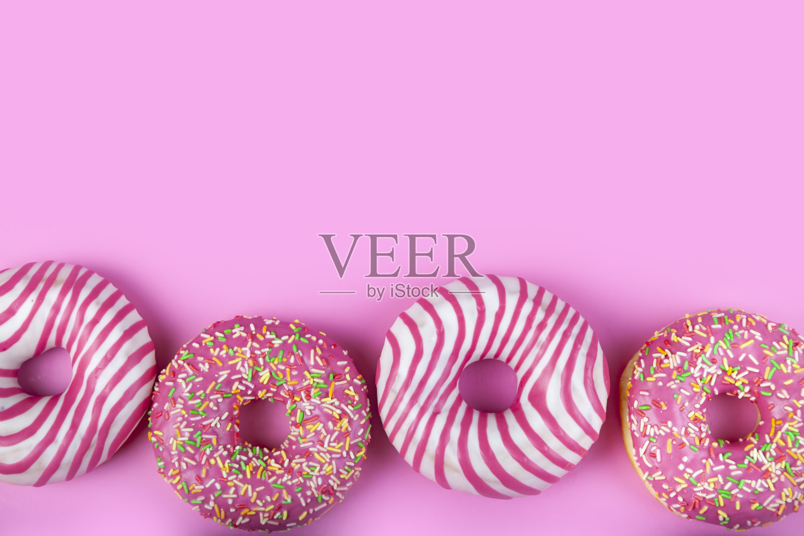 粉色背景上的甜甜圈。照片摄影图片