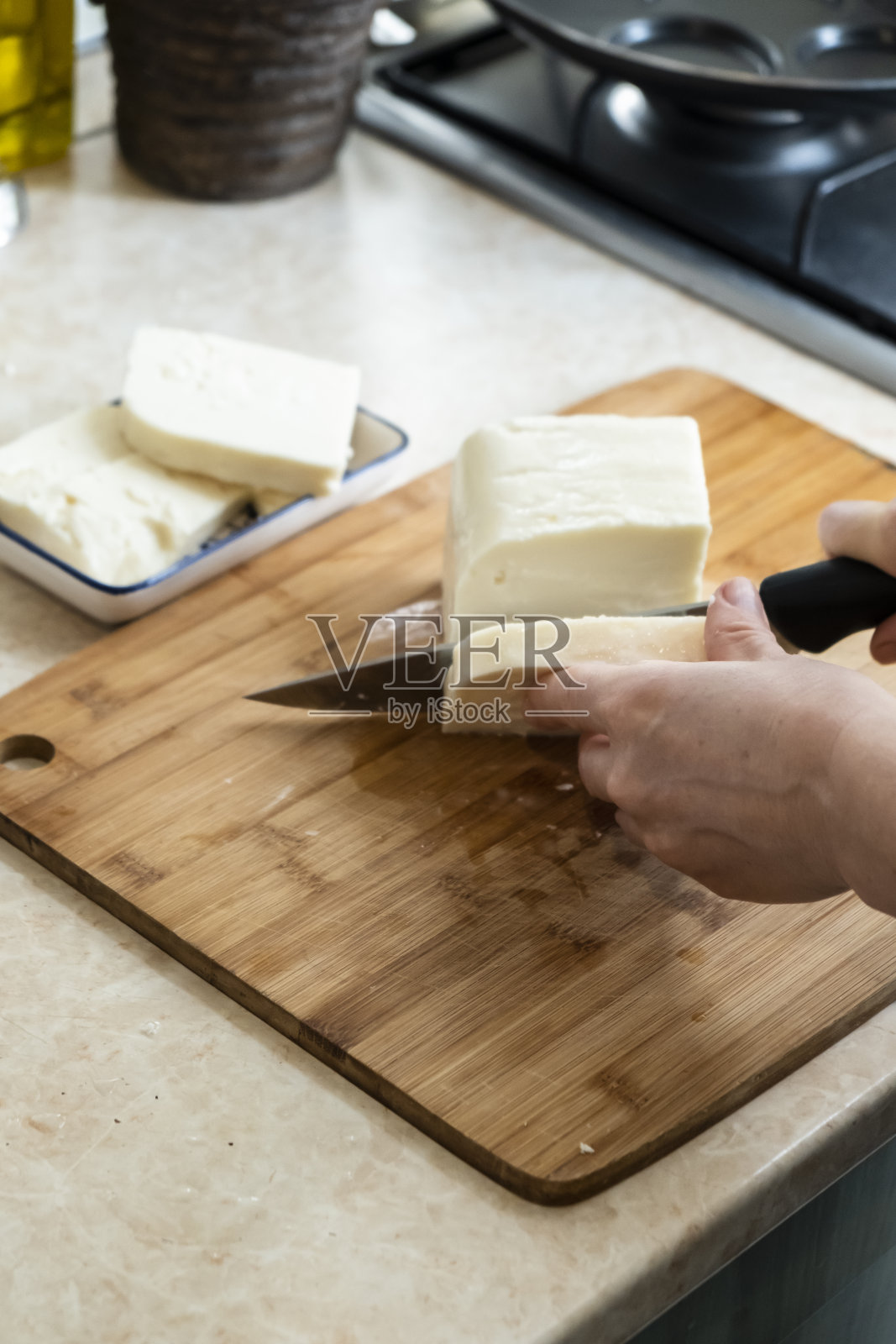 女人正在切羊乳酪准备做早餐照片摄影图片