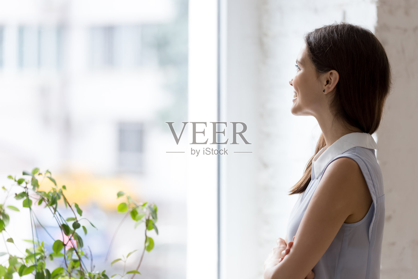 快乐的女商人交叉双臂看着窗外发呆照片摄影图片