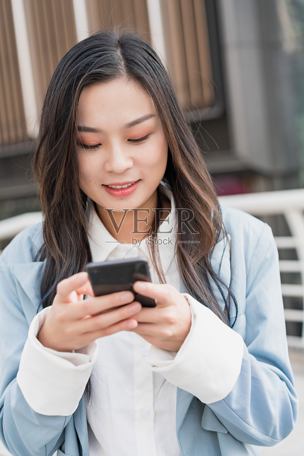 户外使用手机的亚洲年轻女商人照片摄影图片