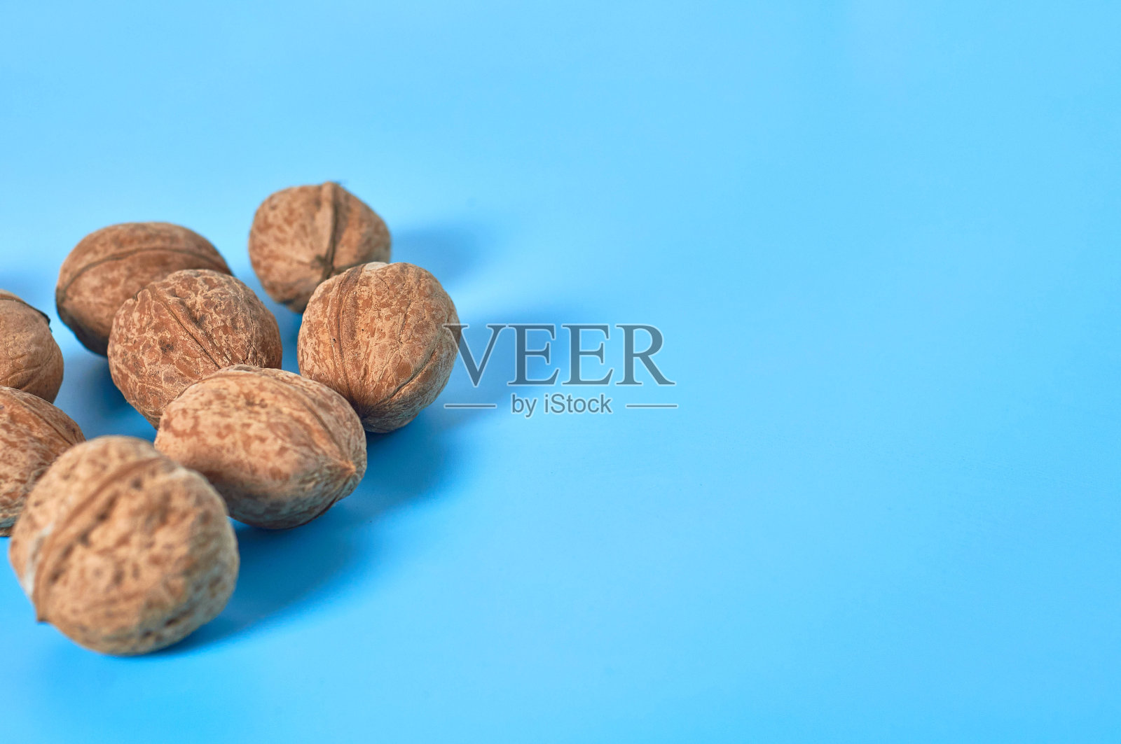 整个成熟的核桃散落在蓝色的背景上。本空间照片摄影图片