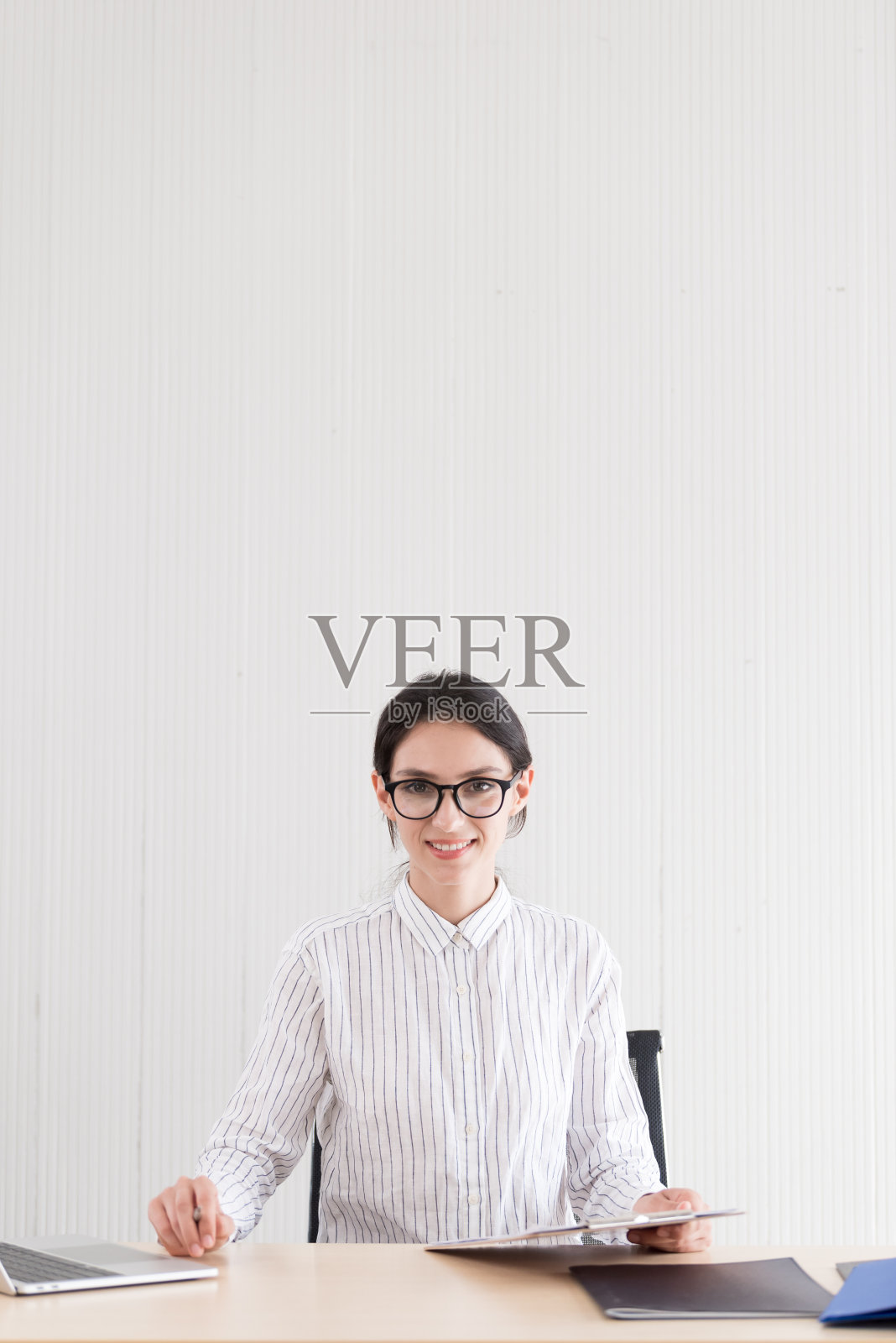 在办公室里带着微笑和幸福工作的戴眼镜的女商人照片摄影图片