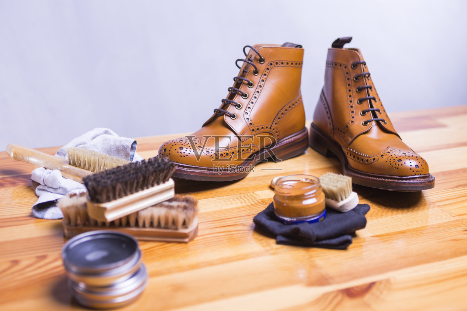 鞋的想法和概念。特写Premium Tan Brogue皮靴与一套清洁配件，蜡和布。专注于鞋子。水平的形象照片摄影图片