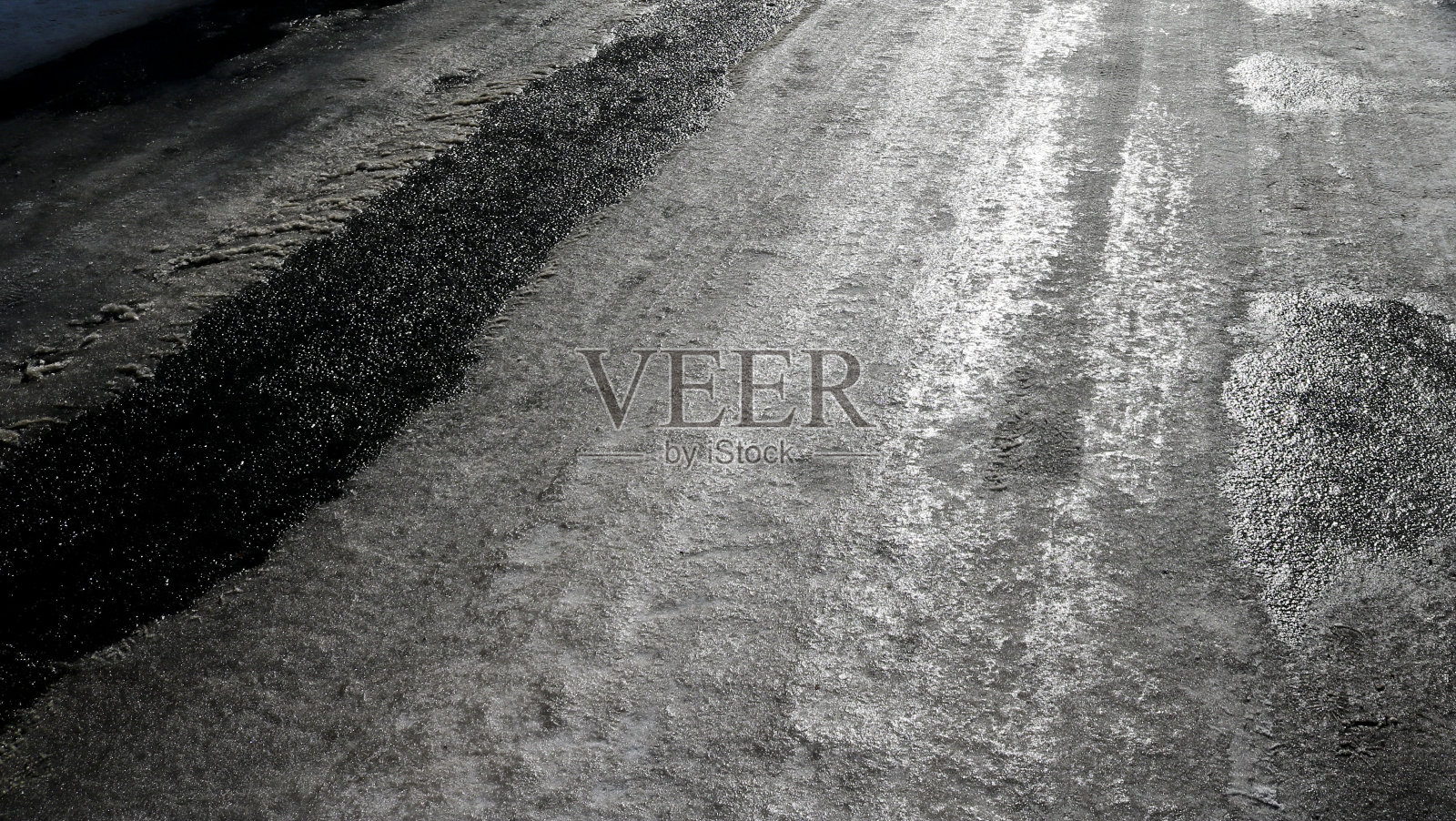 冰冷的道路。有选择性的重点。危险概念，结冰地面。黑白图像。照片摄影图片