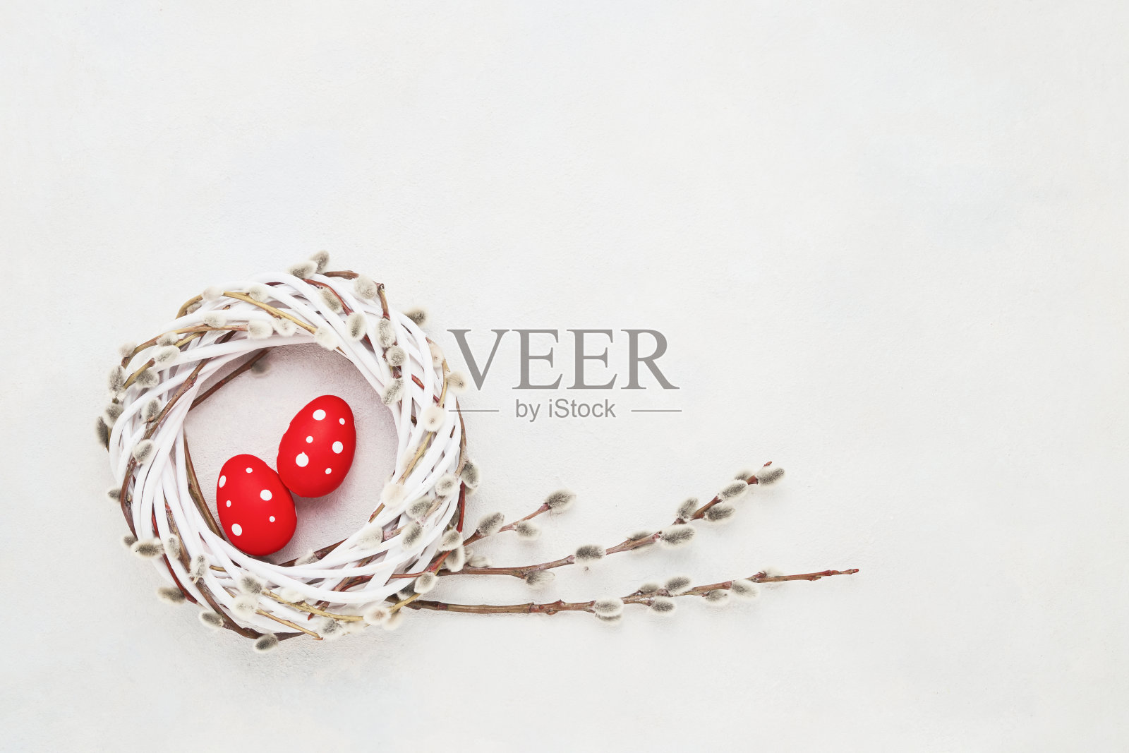 复活节的背景。白色混凝土背景上花环上的红色复活节彩蛋。俯视图，复制空间照片摄影图片