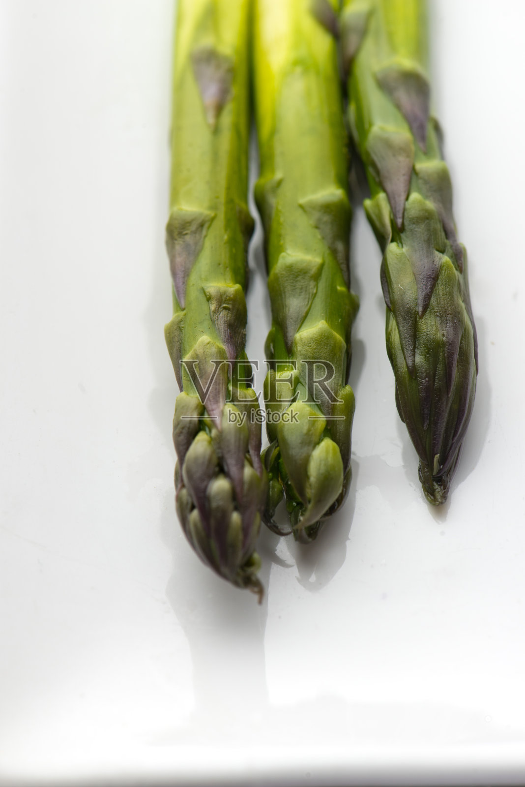 芦笋烤。种植新鲜的有机芦笋茎，切薄片并去皮。用盐和胡椒粉调味，淋上橄榄油和柠檬汁，淋上蒜汁。照片摄影图片