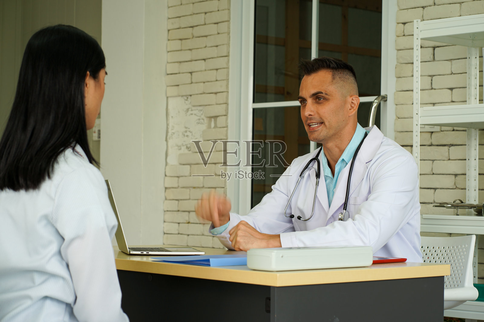 年轻的亚洲女性病人向欧洲医生咨询病毒感染照片摄影图片