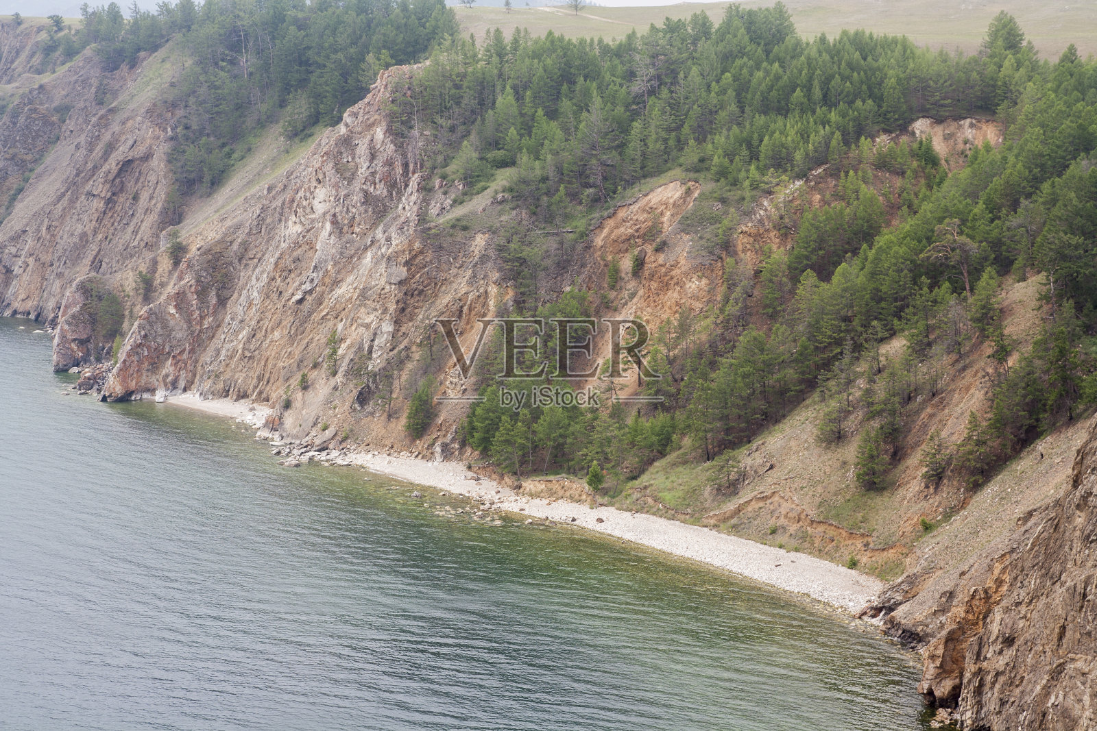 高而多岩石的海岸线，大海中的悬崖，湖泊和水面上的雾照片摄影图片