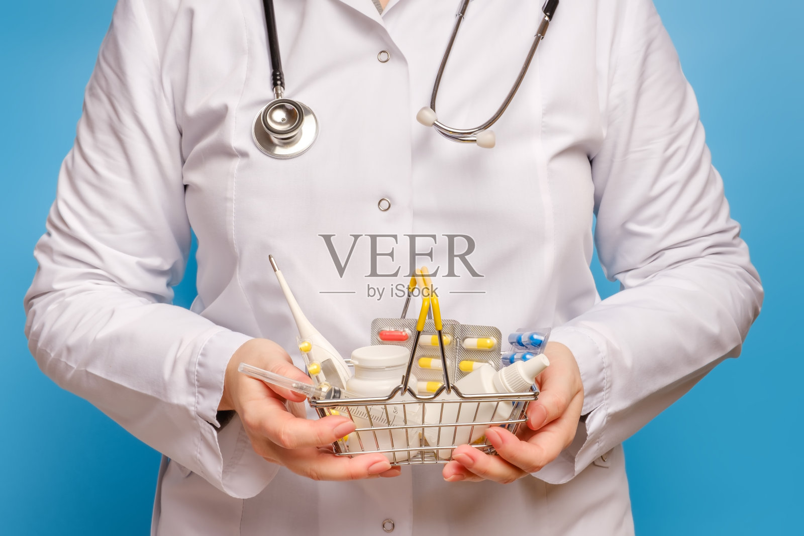 医生手拿装满各种药丸和药片的购物车照片摄影图片